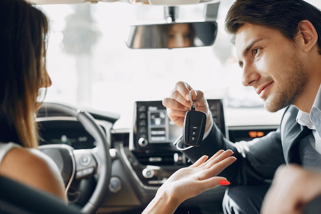 Pareja elegante y elegante en un salón de autos