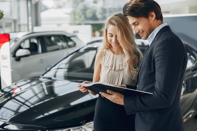 Pareja elegante y elegante en un salón de autos