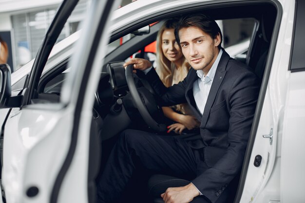 Pareja elegante y elegante en un salón de autos