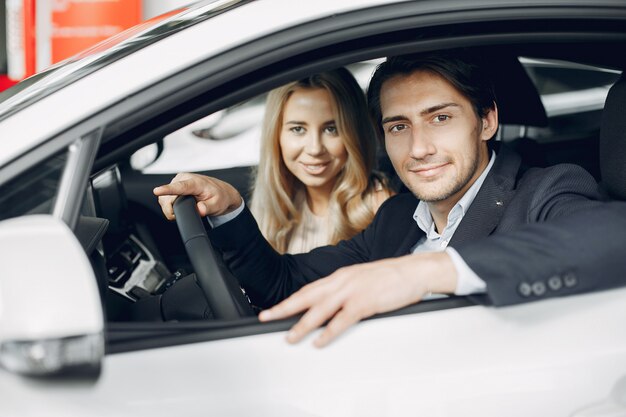 Pareja elegante y elegante en un salón de autos