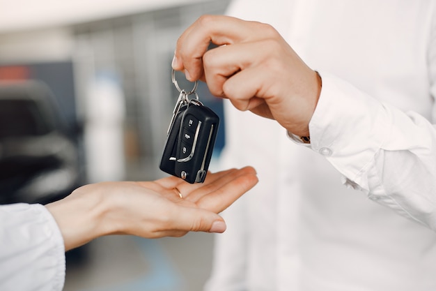 Pareja elegante y elegante en un salón de autos