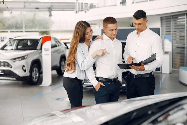 Pareja elegante y elegante en un salón de autos