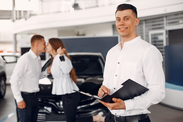 Pareja elegante y elegante en un salón de autos