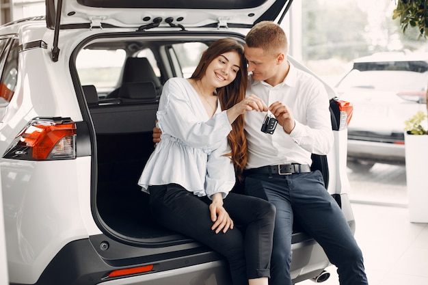 Pareja elegante y elegante en un salón de autos