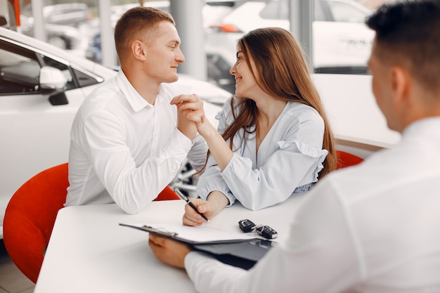 Pareja elegante y elegante en un salón de autos