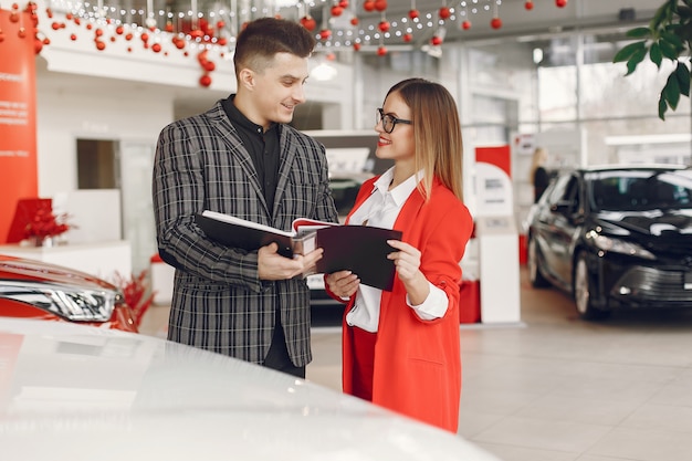 Pareja elegante y elegante en un salón de autos