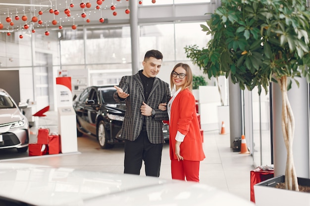 Pareja elegante y elegante en un salón de autos