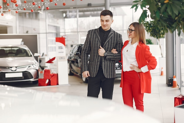 Pareja elegante y elegante en un salón de autos