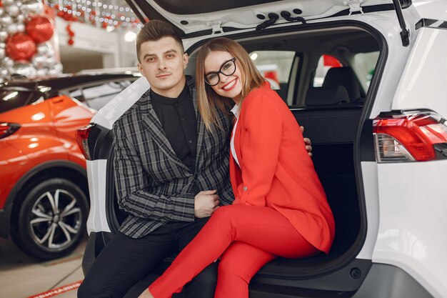 Pareja elegante y elegante en un salón de autos