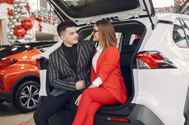 Pareja elegante y elegante en un salón de autos