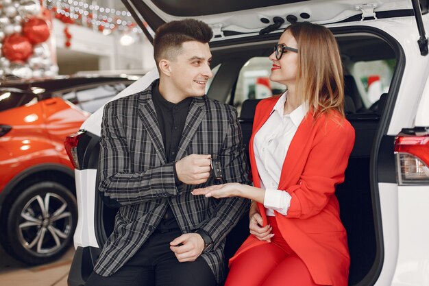 Pareja elegante y elegante en un salón de autos