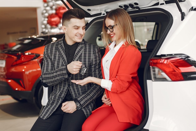 Pareja elegante y elegante en un salón de autos