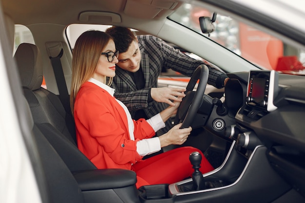 Pareja elegante y elegante en un salón de autos