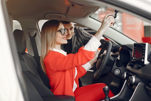 Pareja elegante y elegante en un salón de autos