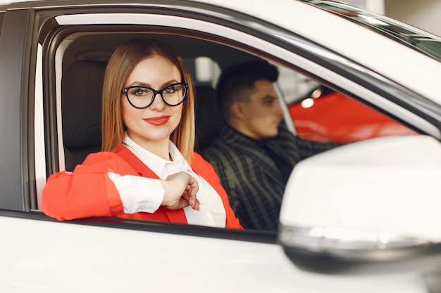 Pareja elegante y elegante en un salón de autos