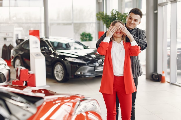 Pareja elegante y elegante en un salón de autos