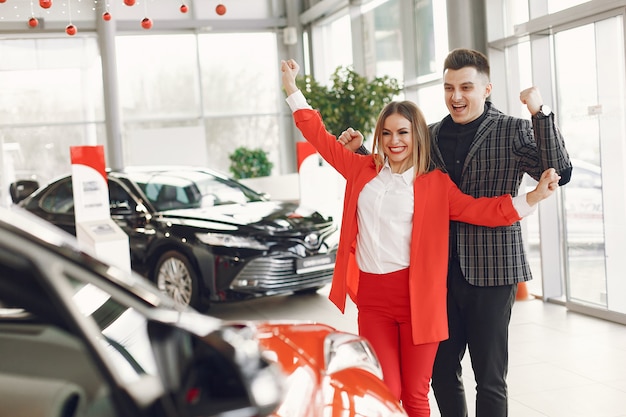 Pareja elegante y elegante en un salón de autos