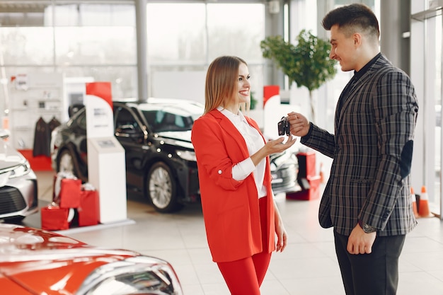 Foto gratuita pareja elegante y elegante en un salón de autos