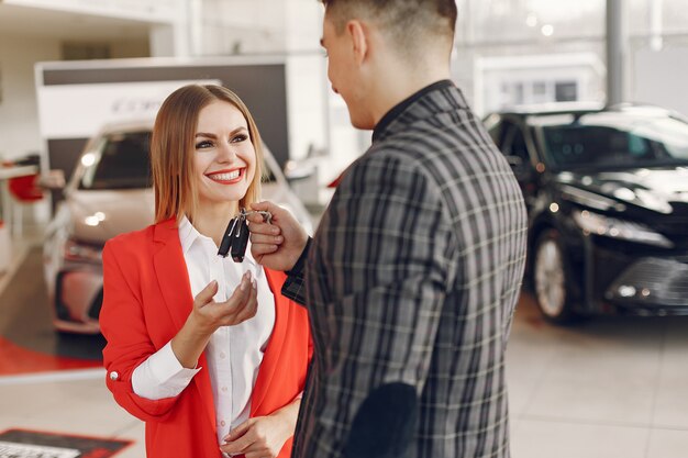 Pareja elegante y elegante en un salón de autos