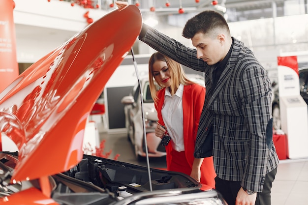 Pareja elegante y elegante en un salón de autos