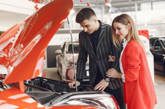 Pareja elegante y elegante en un salón de autos