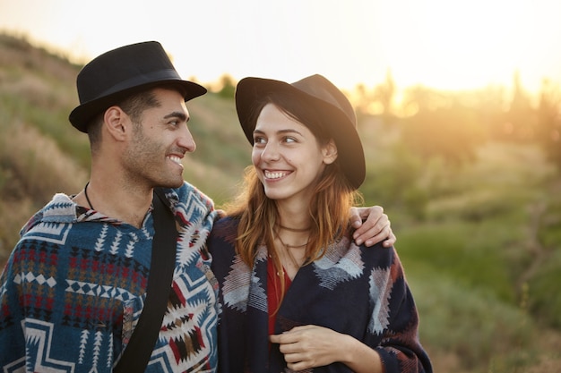 Pareja elegante con guitarra en campo