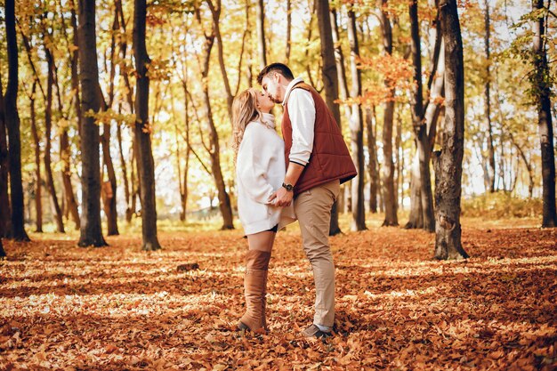 Pareja elegante en un parque soleado de otoño