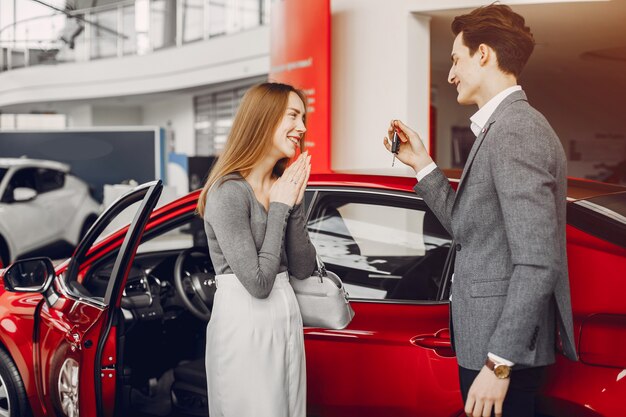 Pareja elegante en un salón de autos