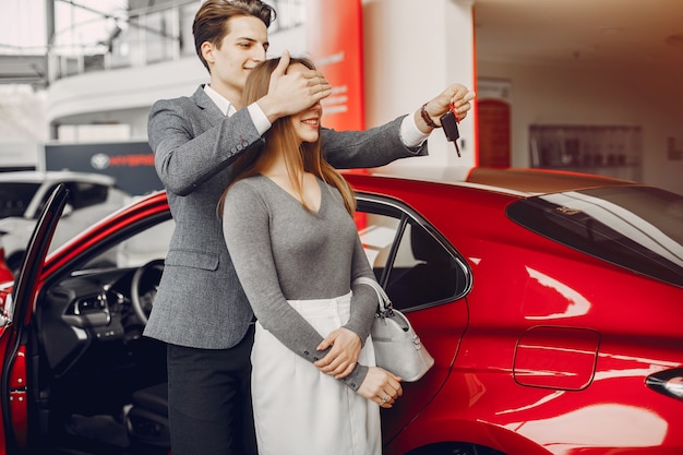 Pareja elegante en un salón de autos