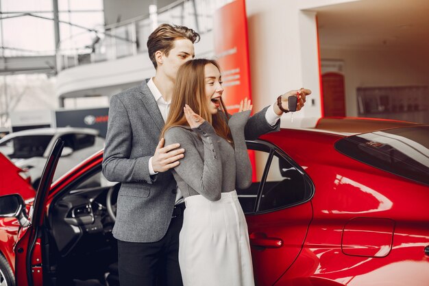 Pareja elegante en un salón de autos