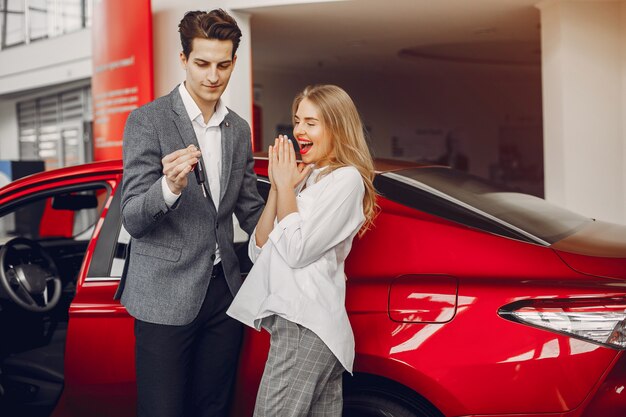 Pareja elegante en un salón de autos