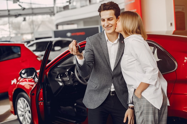 Pareja elegante en un salón de autos