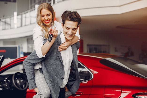 Pareja elegante en un salón de autos