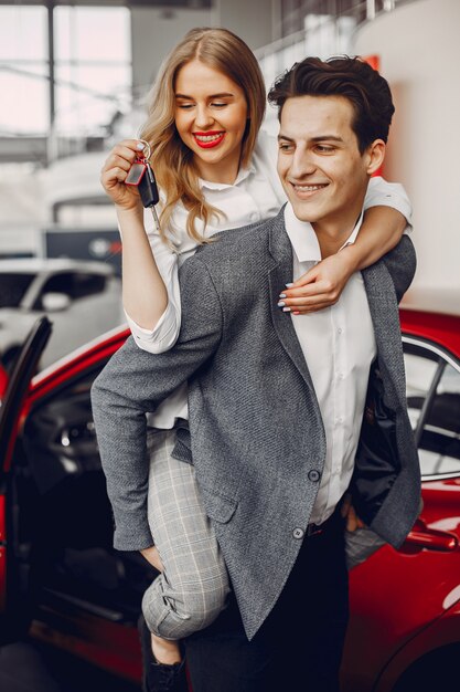 Pareja elegante en un salón de autos