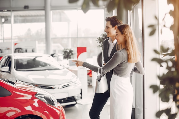 Pareja elegante en un salón de autos