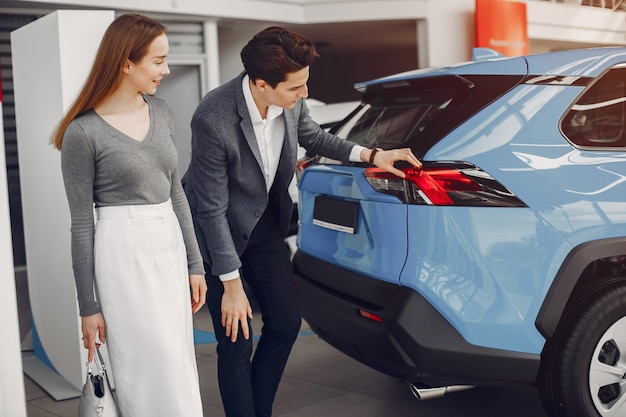 Pareja elegante en un salón de autos