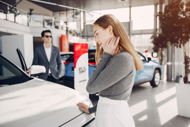 Foto gratuita pareja elegante en un salón de autos