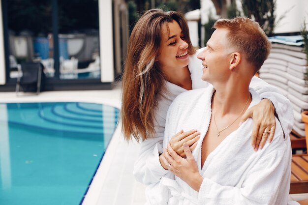 Pareja elegante sentado cerca de una piscina