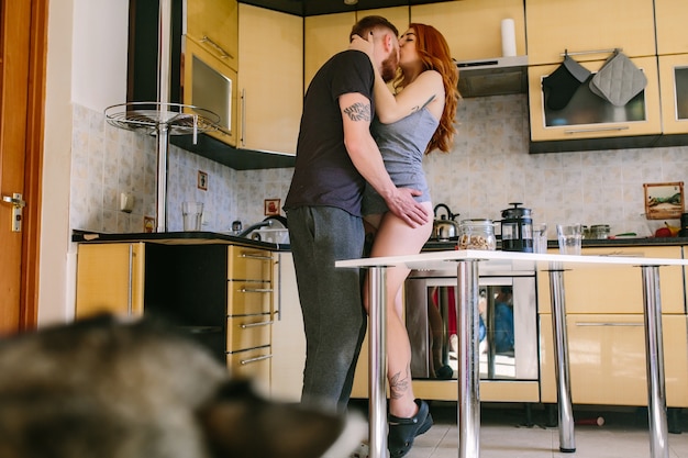 Pareja enamorada besándose en la cocina