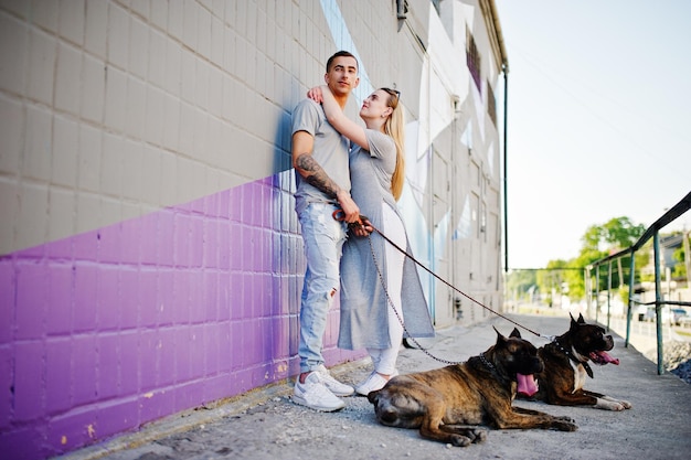 Foto gratuita pareja enamorada de dos perros pit bull terrier en un paseo