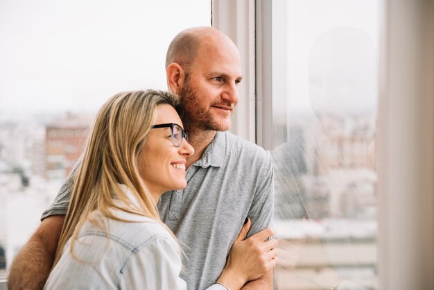 Pareja enamorada enfrente de ventana