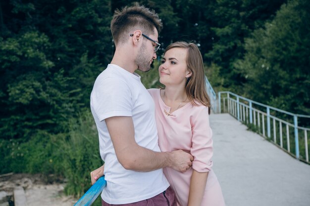 Pareja enamorada mirándose a los ojos en un puente