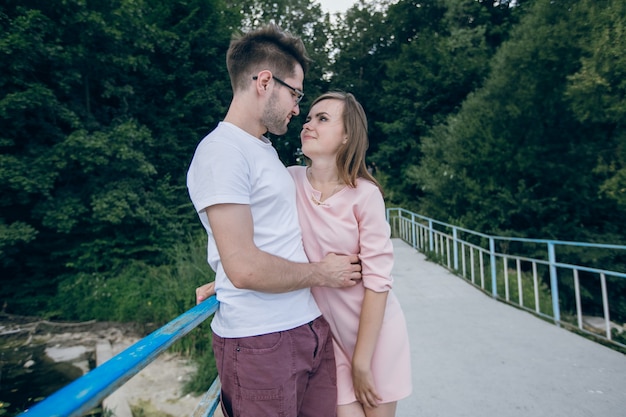 Foto gratuita pareja enamorada mirándose a los ojos en un puente