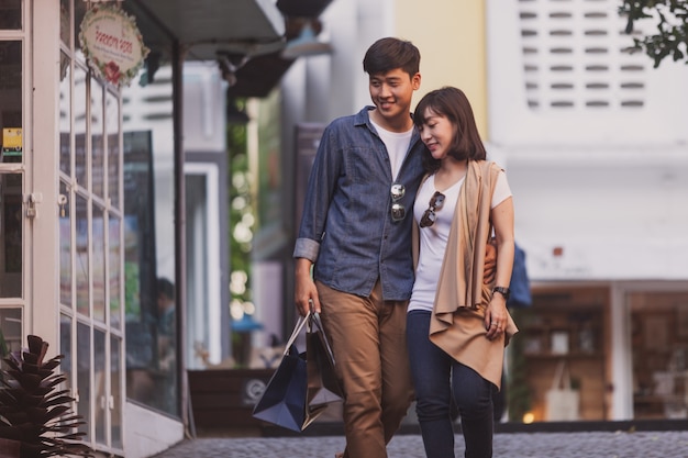 Pareja enamorada paseando con bolsas de compras