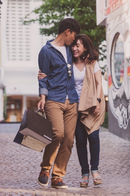 Foto gratuita pareja enamorada paseando con bolsas de compras