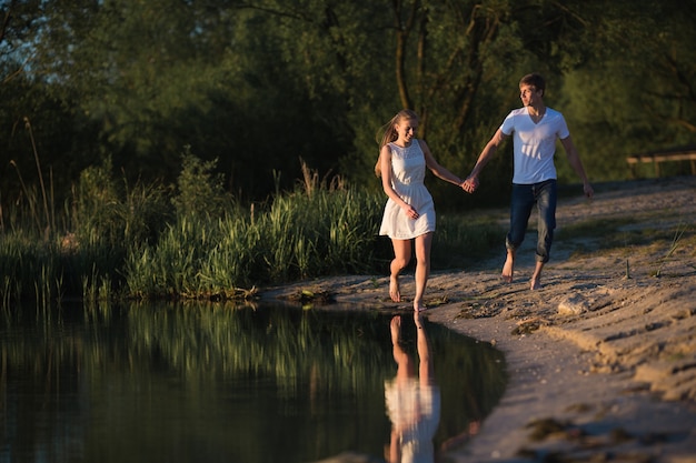 Pareja enamorada paseando por la orilla