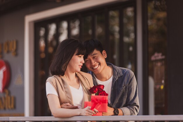 Pareja enamorada sujetando un regalo rojo