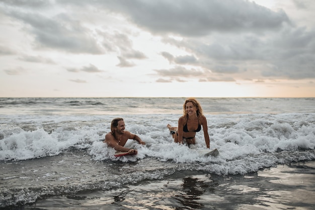 Pareja enamorada va a surfear juntos