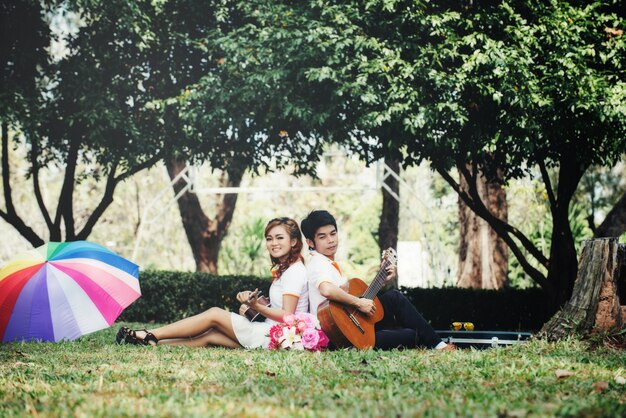 Pareja enamorada de tocar la guitarra en la naturaleza