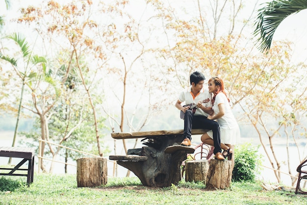 Pareja enamorada de tocar la guitarra en la naturaleza